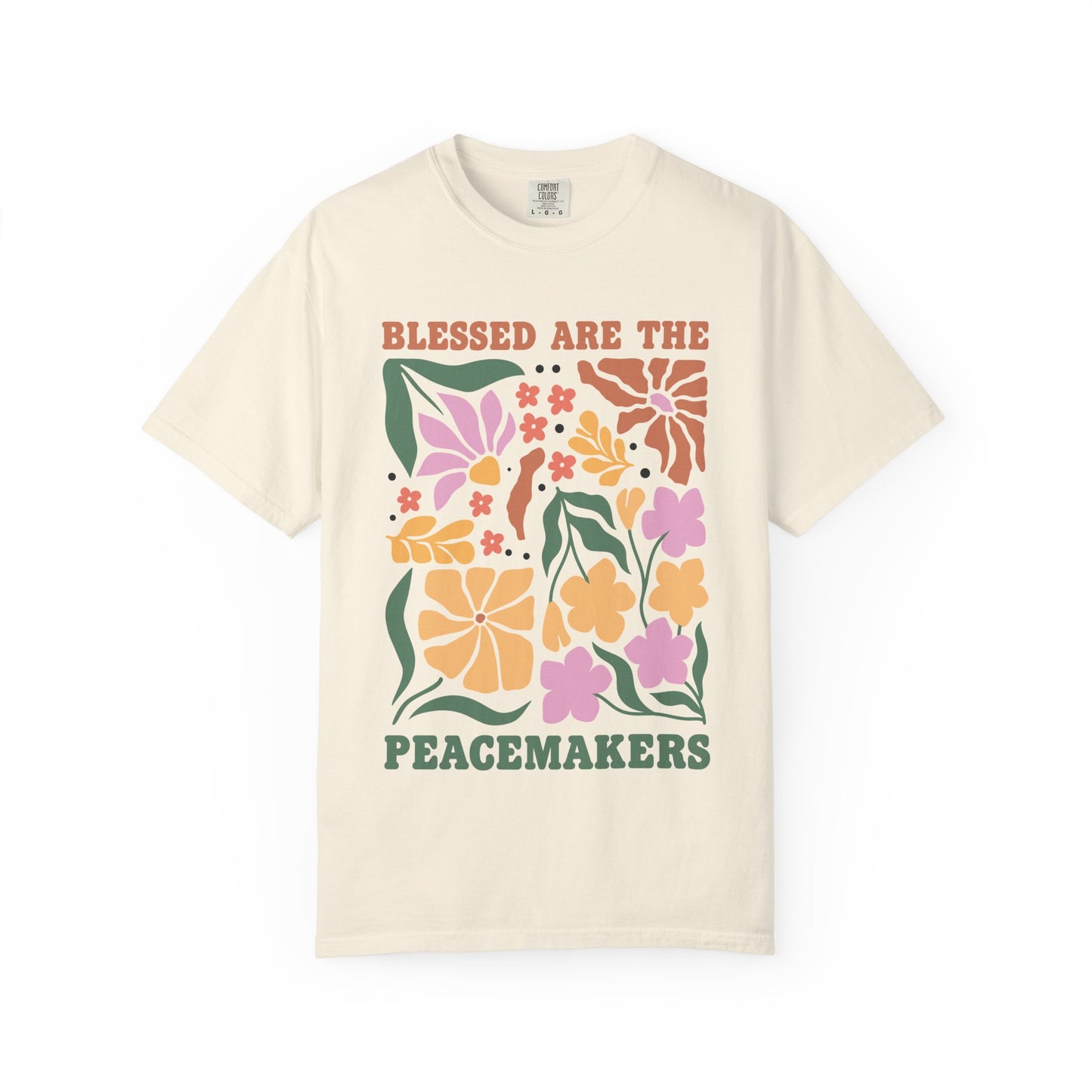 T-shirt with 'Blessed Are The Peacemakers' text surrounded by colorful floral design in pink, coral, yellow and green