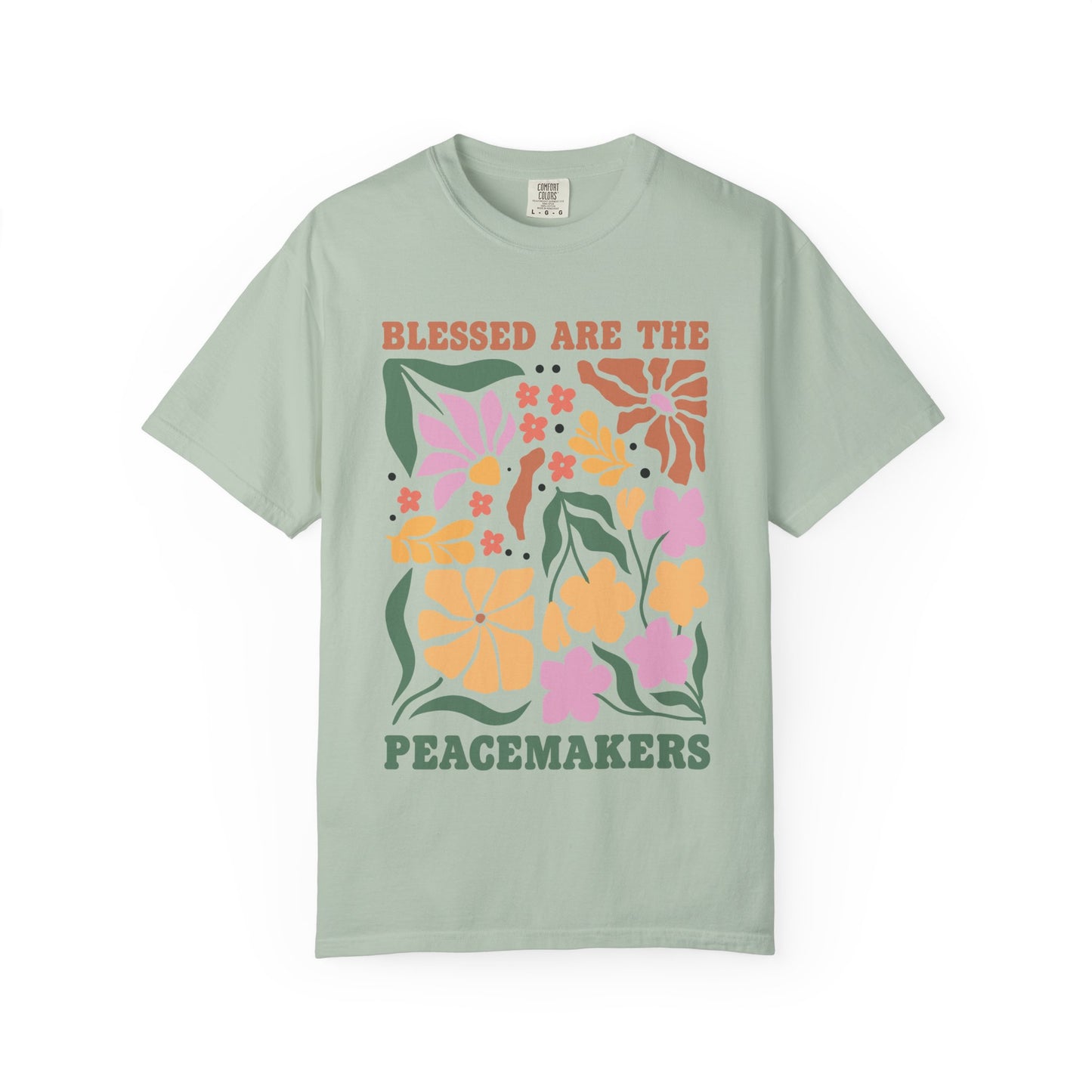 T-shirt with 'Blessed Are The Peacemakers' text surrounded by colorful floral design in pink, coral, yellow and green