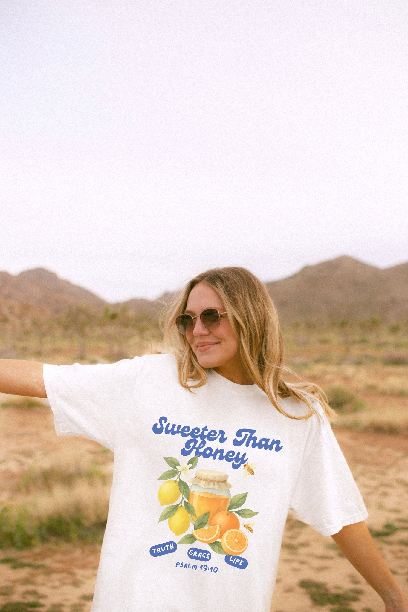 Christian t-shirt with Sweeter Than Honey Psalm 19:10 design featuring watercolor honey jar, citrus fruits, and bees