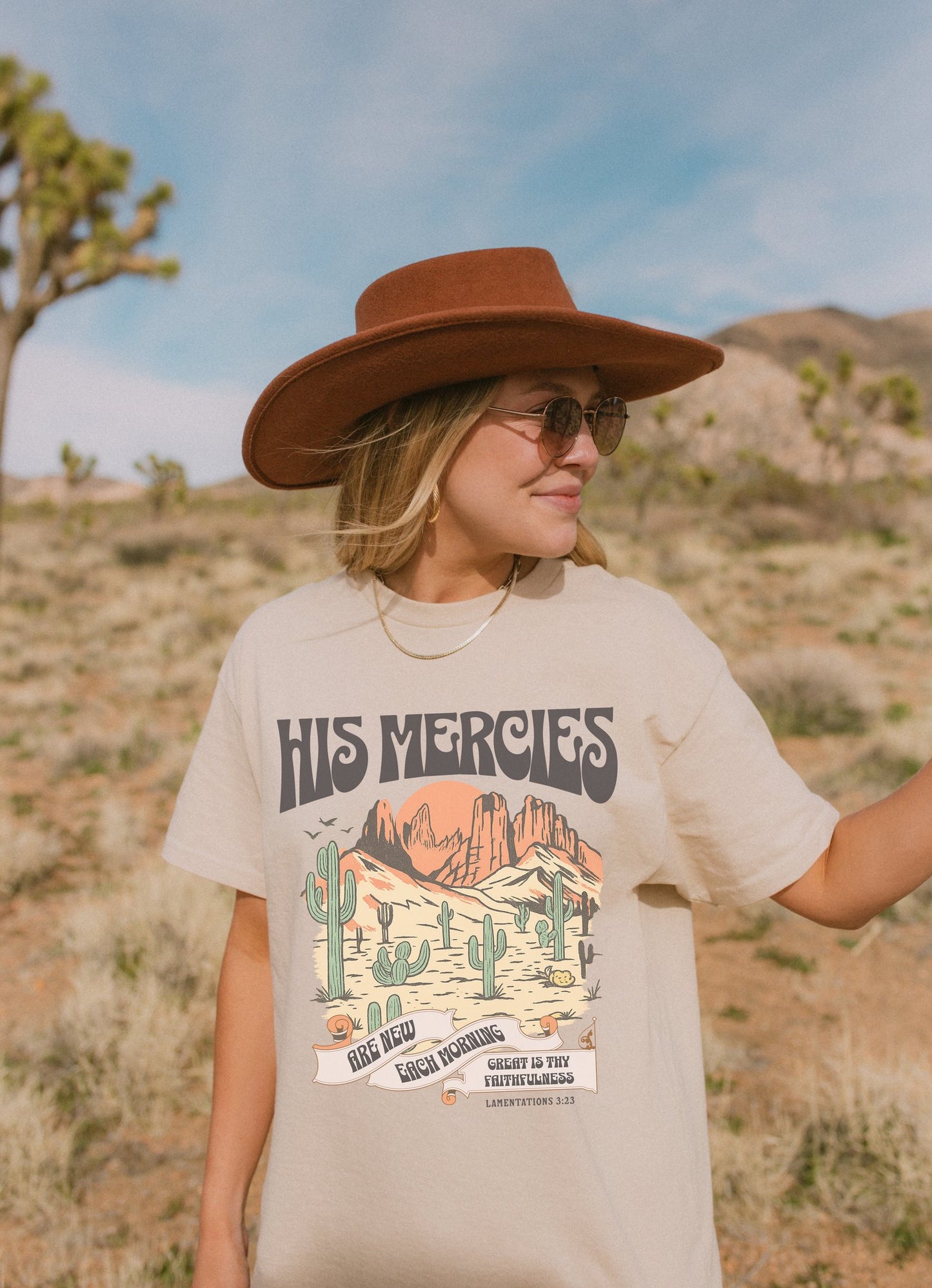 Christian t-shirt with desert landscape design featuring 'His Mercies Are New Each Morning' text and Lamentations 3:23 verse