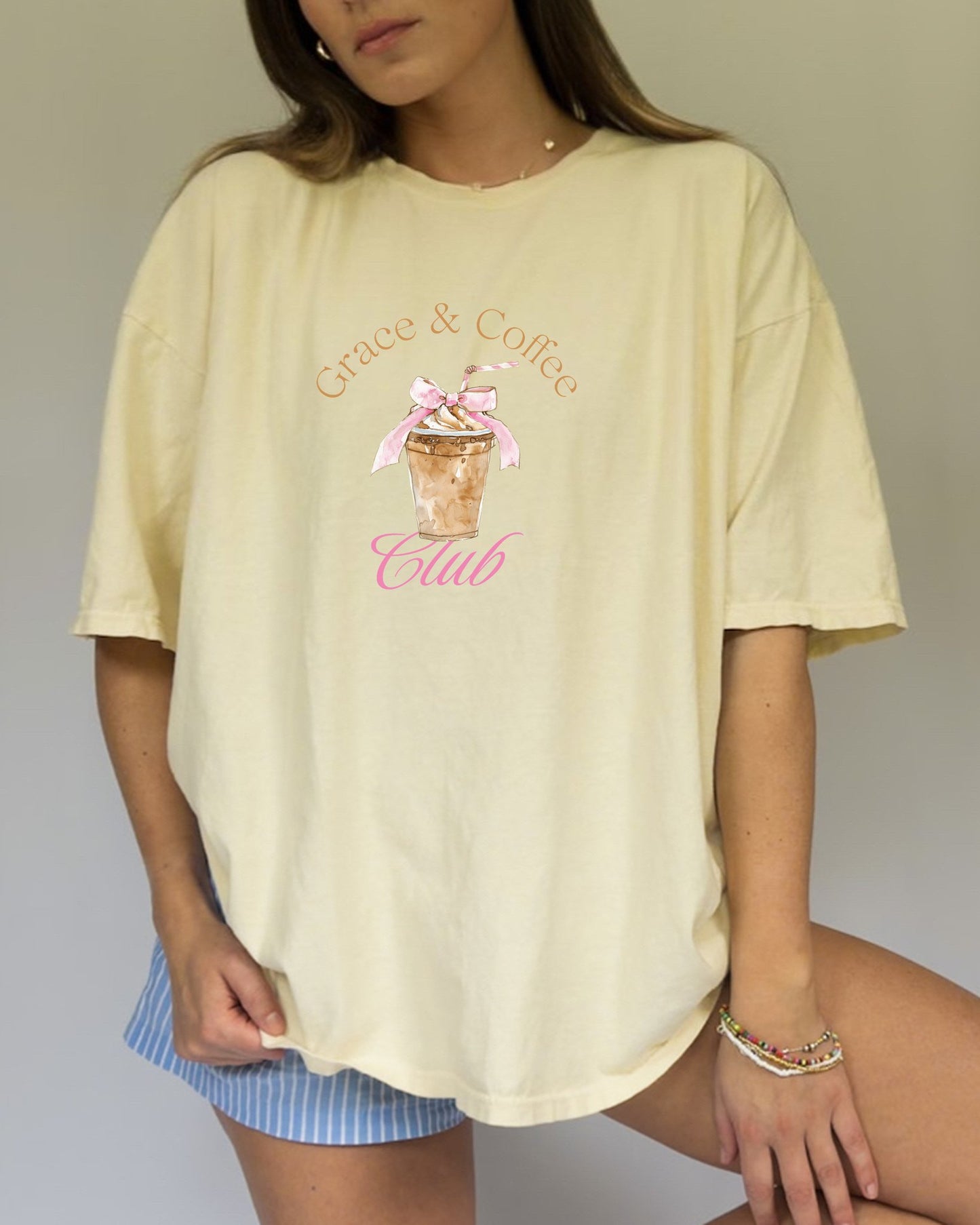 T-shirt with watercolor coffee cup design featuring pink bow and Grace & Coffee Club text
