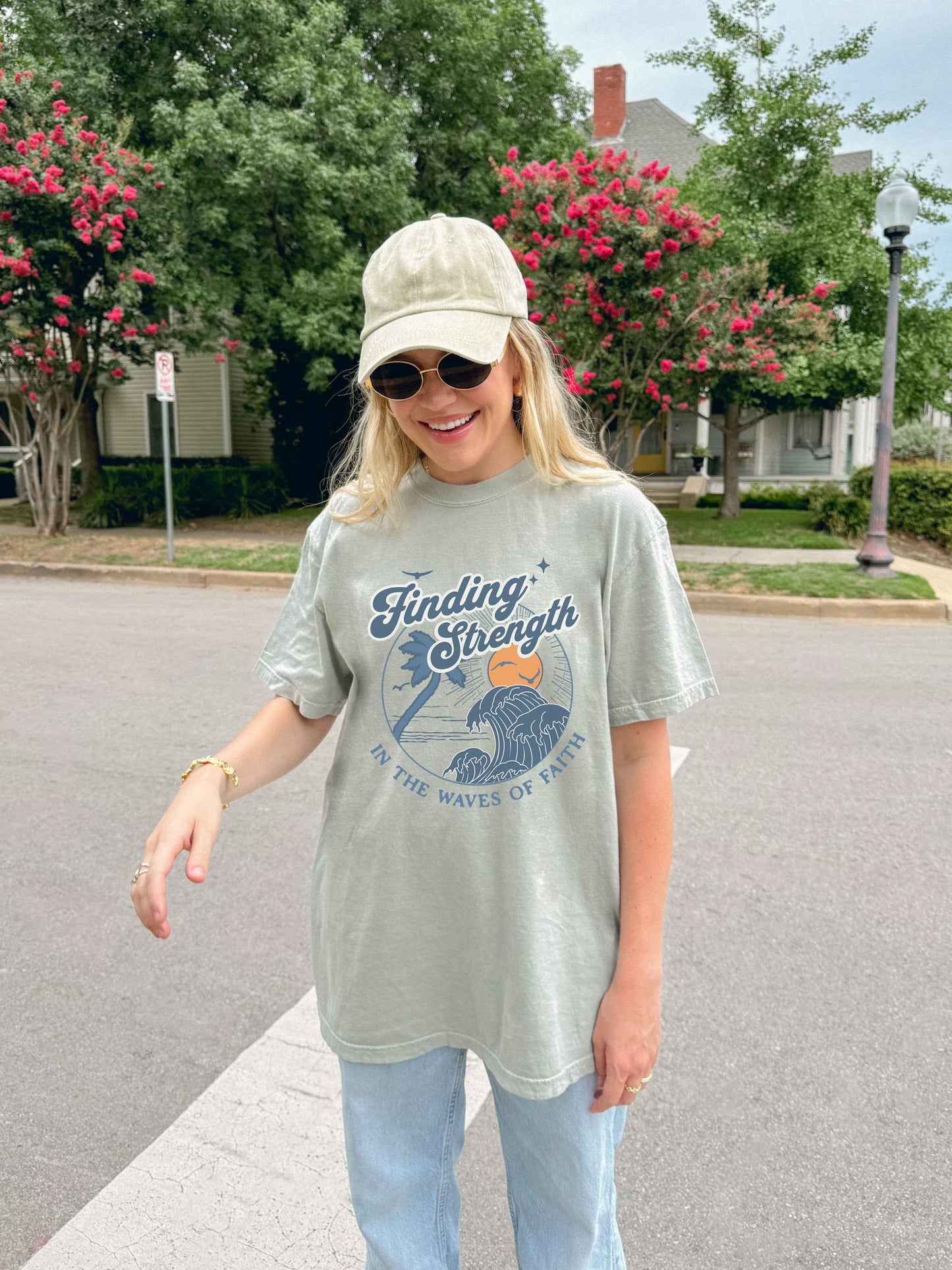 T-shirt with retro Christian design featuring palm tree, sunset, and ocean waves with Finding Strength text