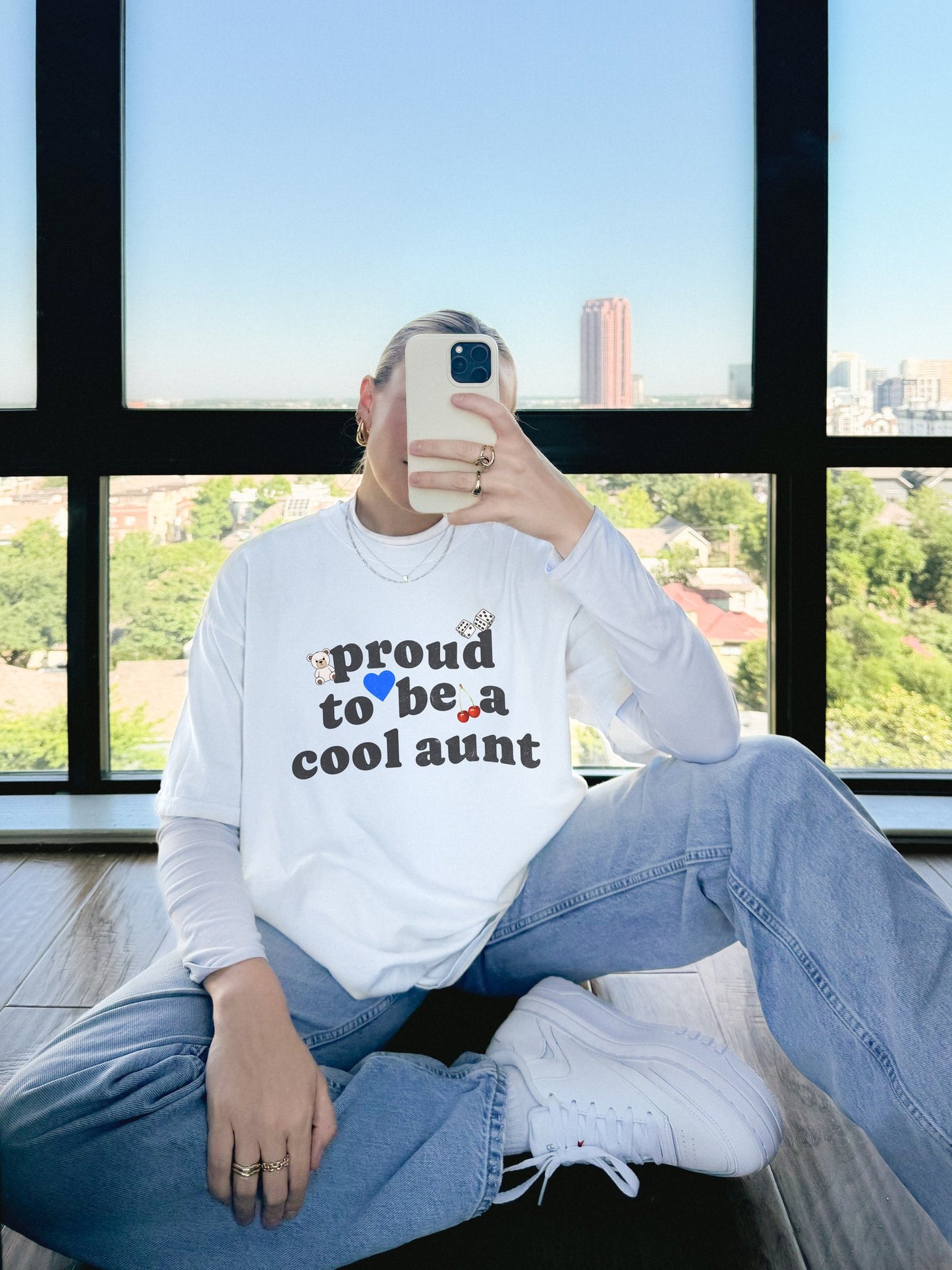 T-shirt with retro distressed text 'proud to be a cool aunt' decorated with teddy bear, blue heart, dice, and cherries