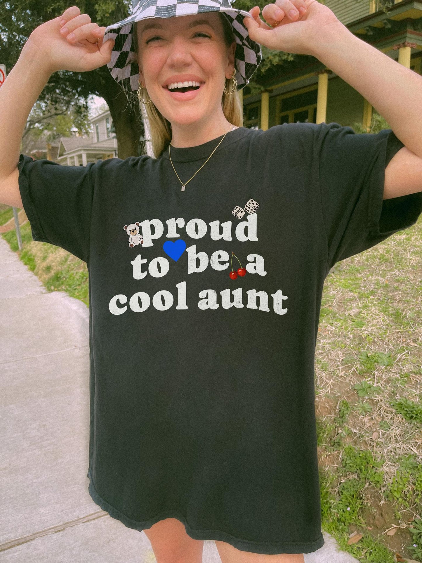 T-shirt with retro distressed text 'proud to be a cool aunt' decorated with teddy bear, blue heart, dice, and cherries