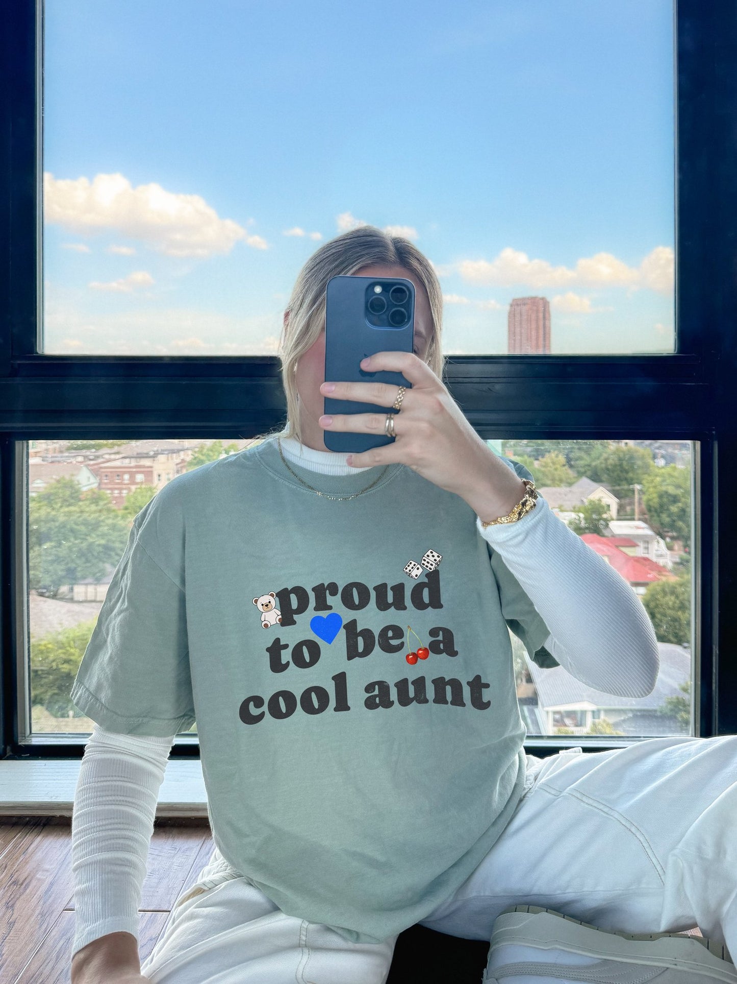T-shirt with retro distressed text 'proud to be a cool aunt' decorated with teddy bear, blue heart, dice, and cherries