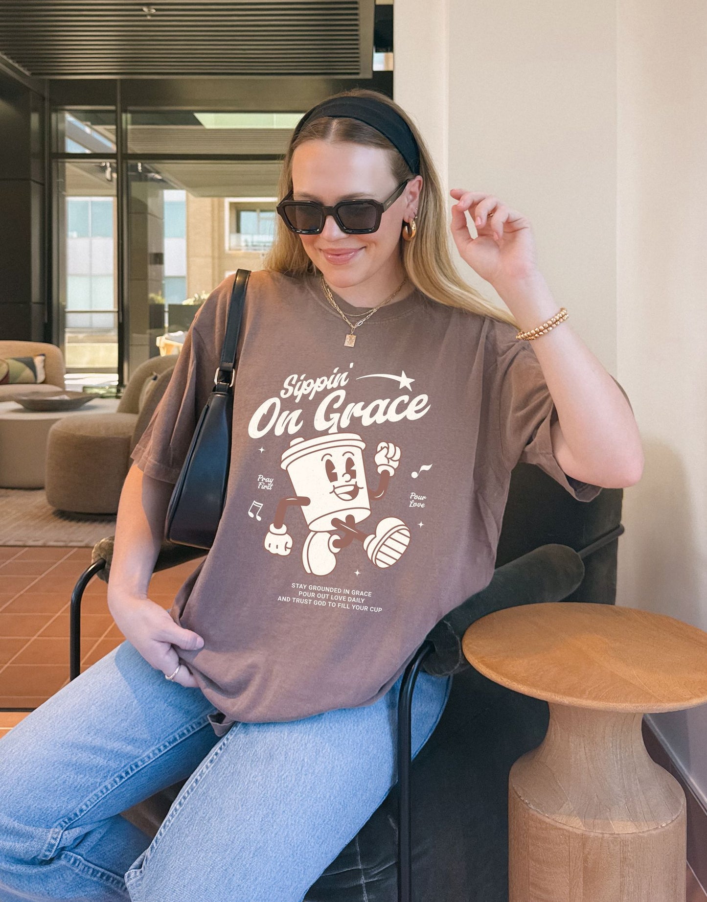 Christian t-shirt with cartoon coffee cup character and 'Sippin' On Grace' text in brown design