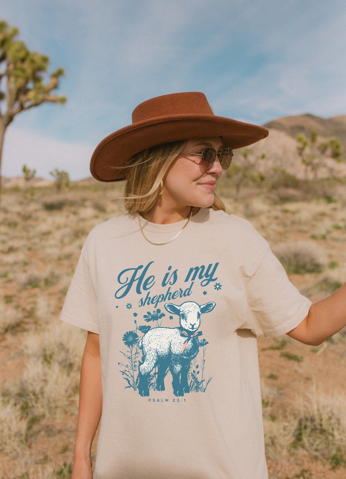 Christian t-shirt featuring adorable lamb with wildflowers and 'He Is My Shepherd' text in teal