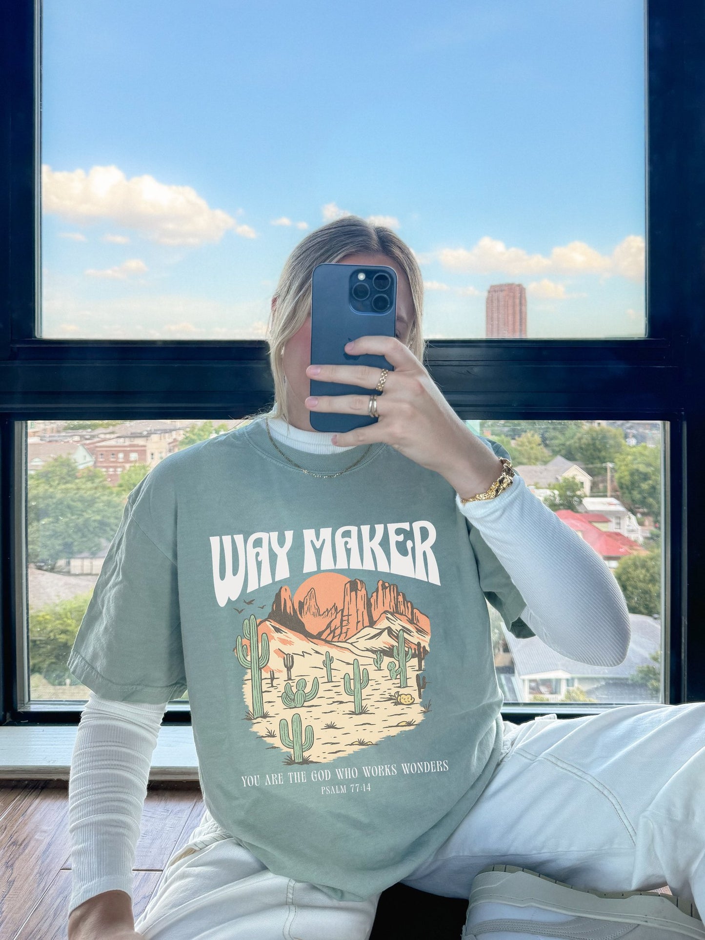 T-shirt with Way Maker text, desert landscape featuring cacti, mountains, and orange sunset with Psalm 77:14 verse
