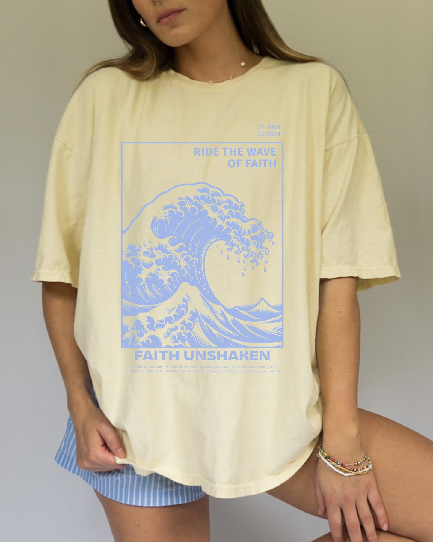 T-shirt with blue ocean wave design featuring 'Ride The Wave Of Faith' and 'Faith Unshaken' text