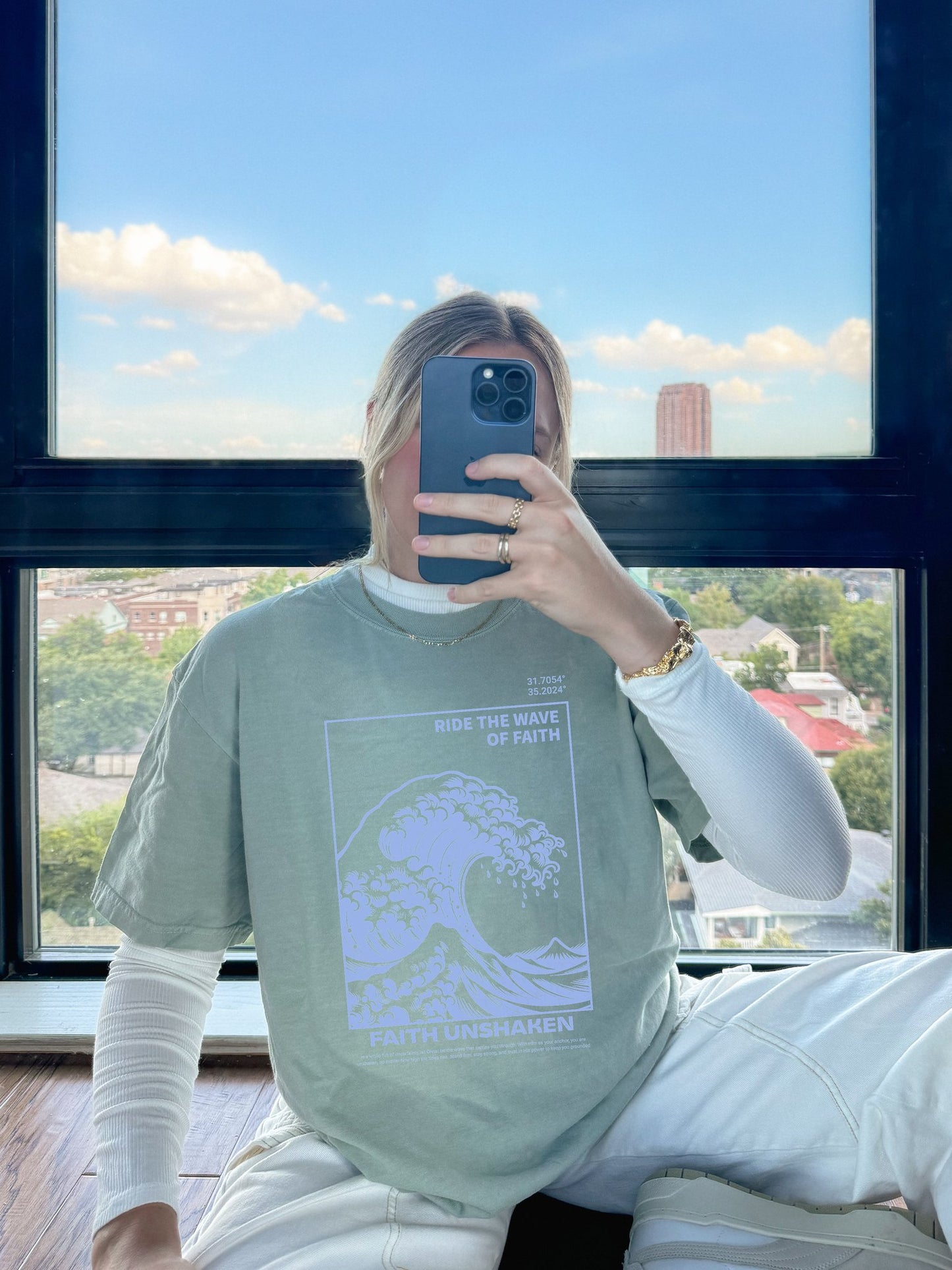 T-shirt with blue ocean wave design featuring 'Ride The Wave Of Faith' and 'Faith Unshaken' text