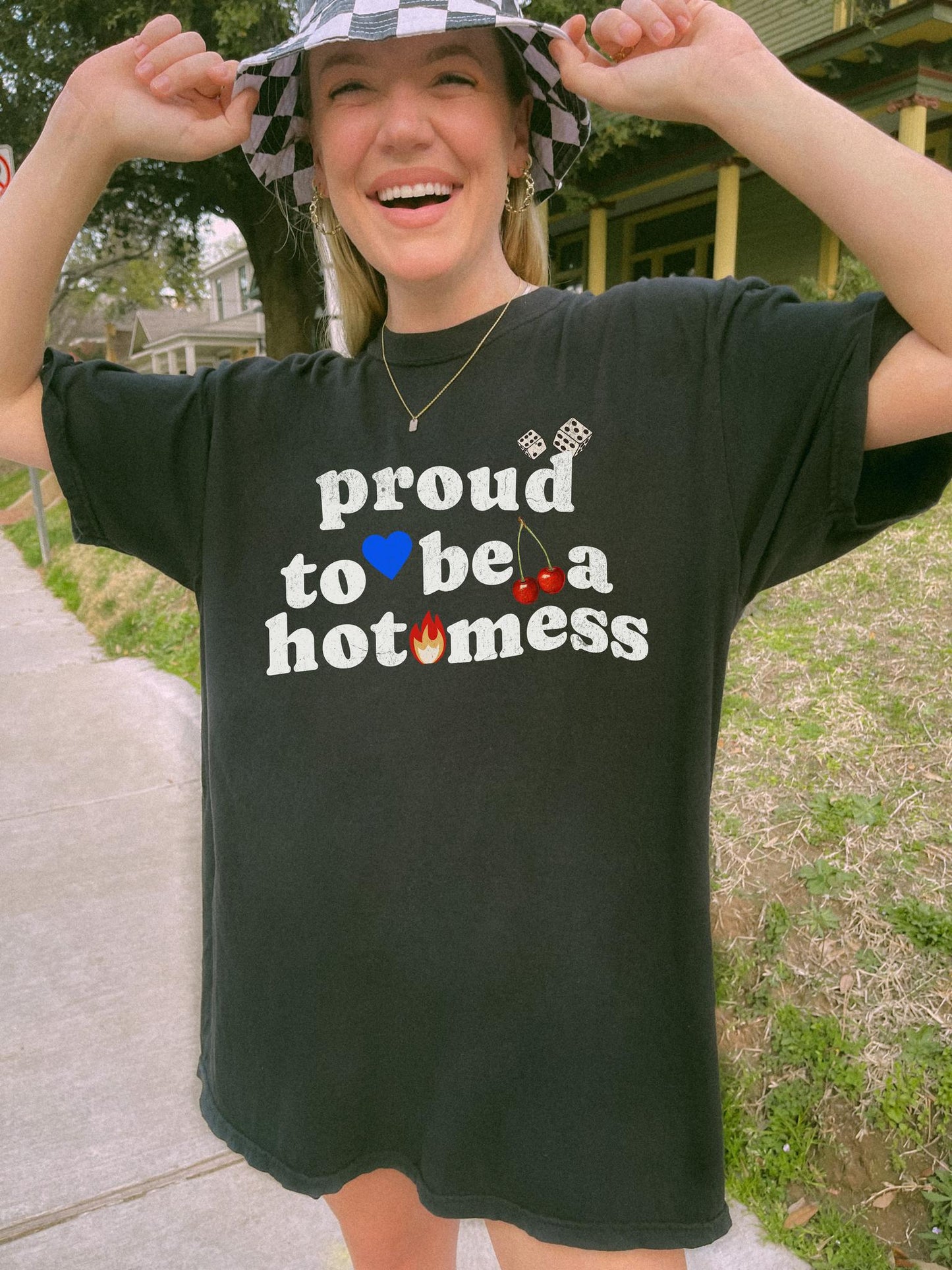 T-shirt with distressed black text reading 'proud to be a hot mess' decorated with dice, blue heart, cherries, and flame graphics