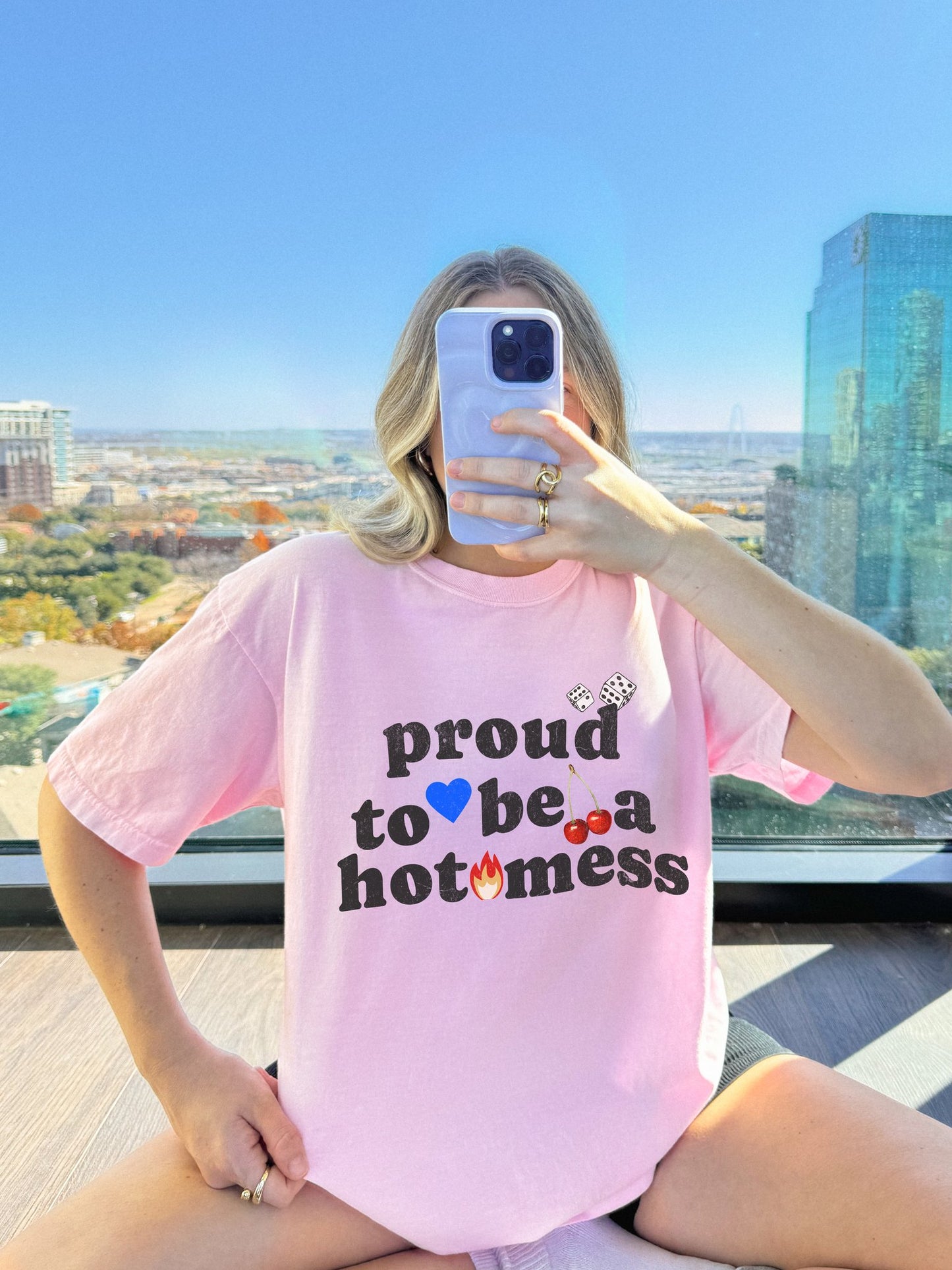 T-shirt with distressed black text reading 'proud to be a hot mess' decorated with dice, blue heart, cherries, and flame graphics