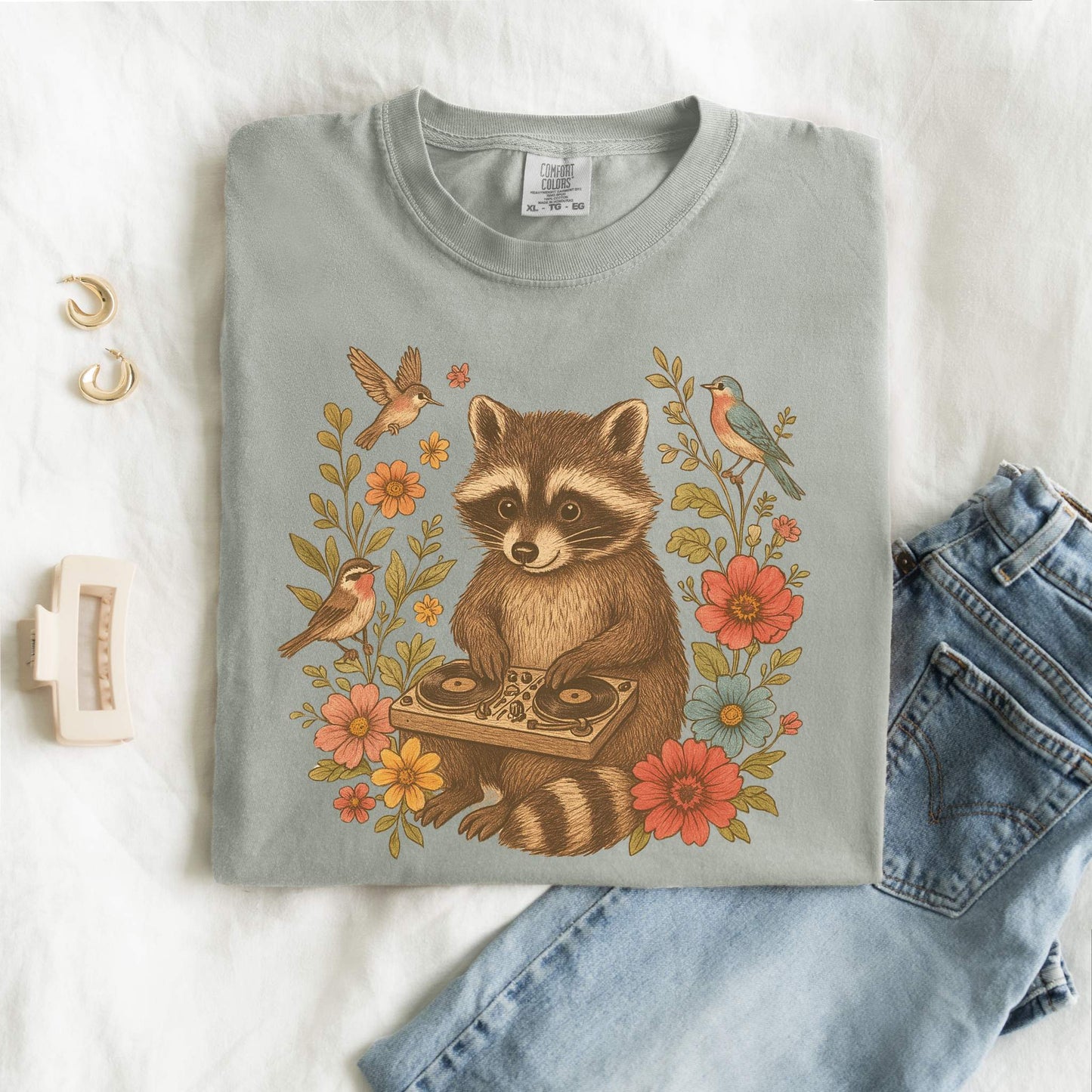 T-shirt with vintage raccoon DJ design surrounded by coral flowers, yellow blooms, and songbirds