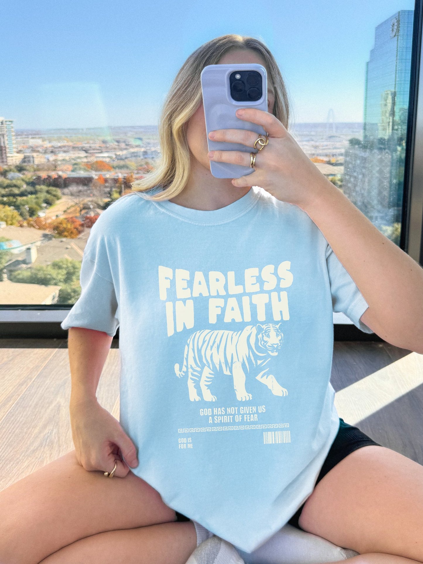 A t-shirt featuring 'Fearless In Faith' text design in elegant cream colored typography
