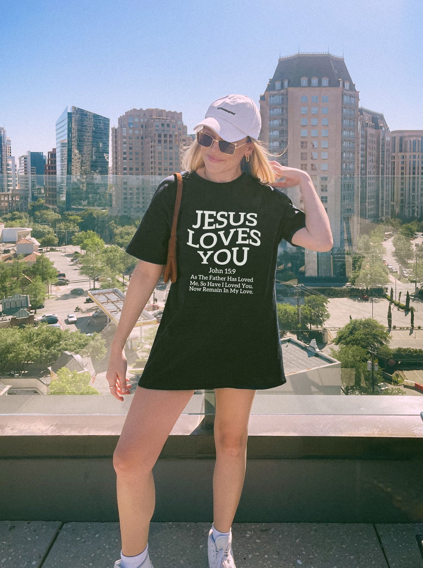 Black text design on t-shirt reading Jesus Loves You with John 15:9 Bible verse