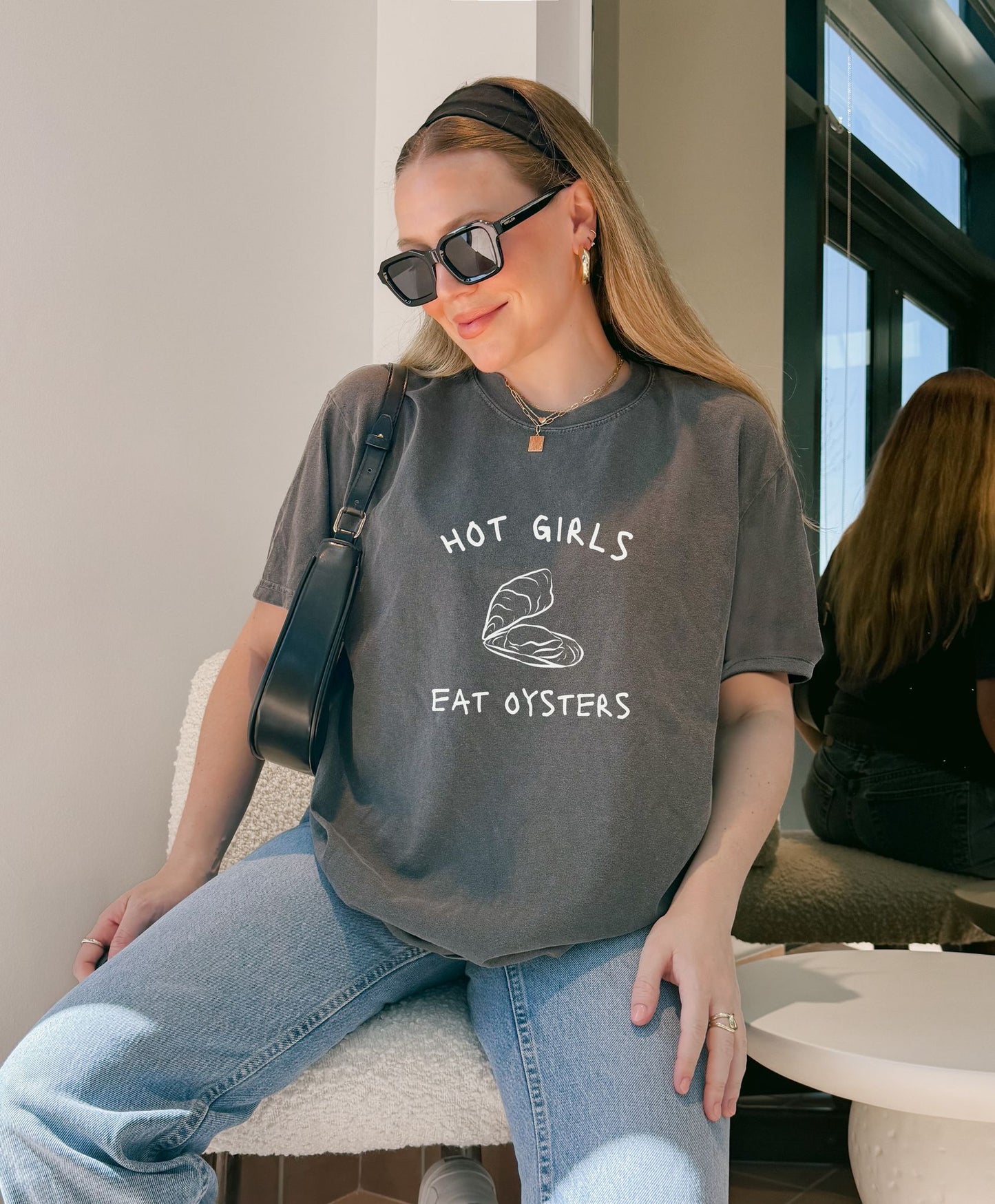 T-shirt with 'Hot Girls Eat Oysters' text and minimalist oyster shell illustration in blue tones
