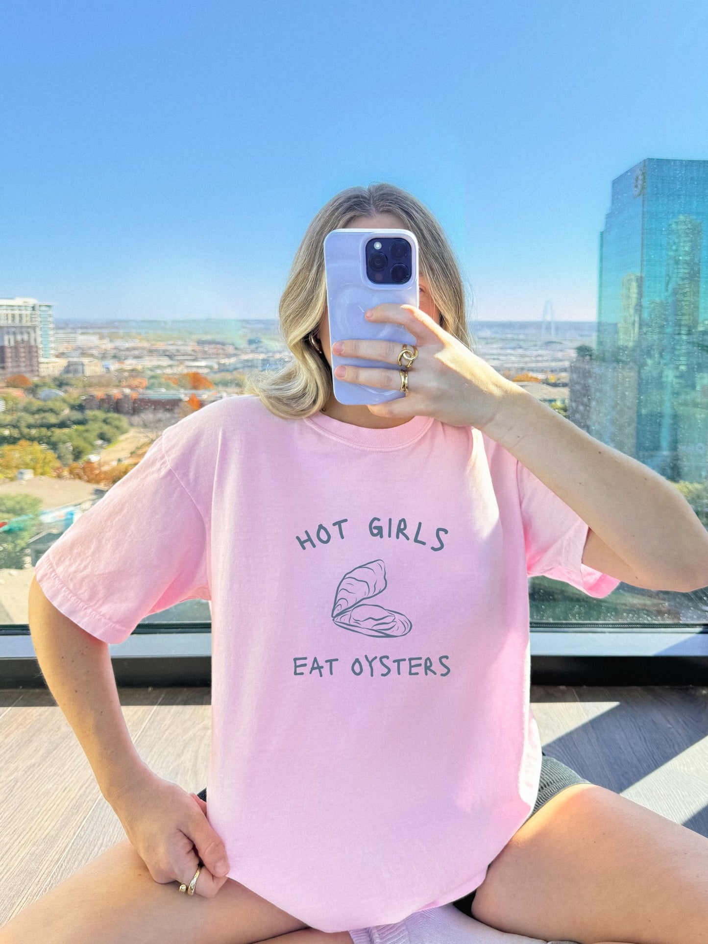 T-shirt with 'Hot Girls Eat Oysters' text and minimalist oyster shell illustration in blue tones