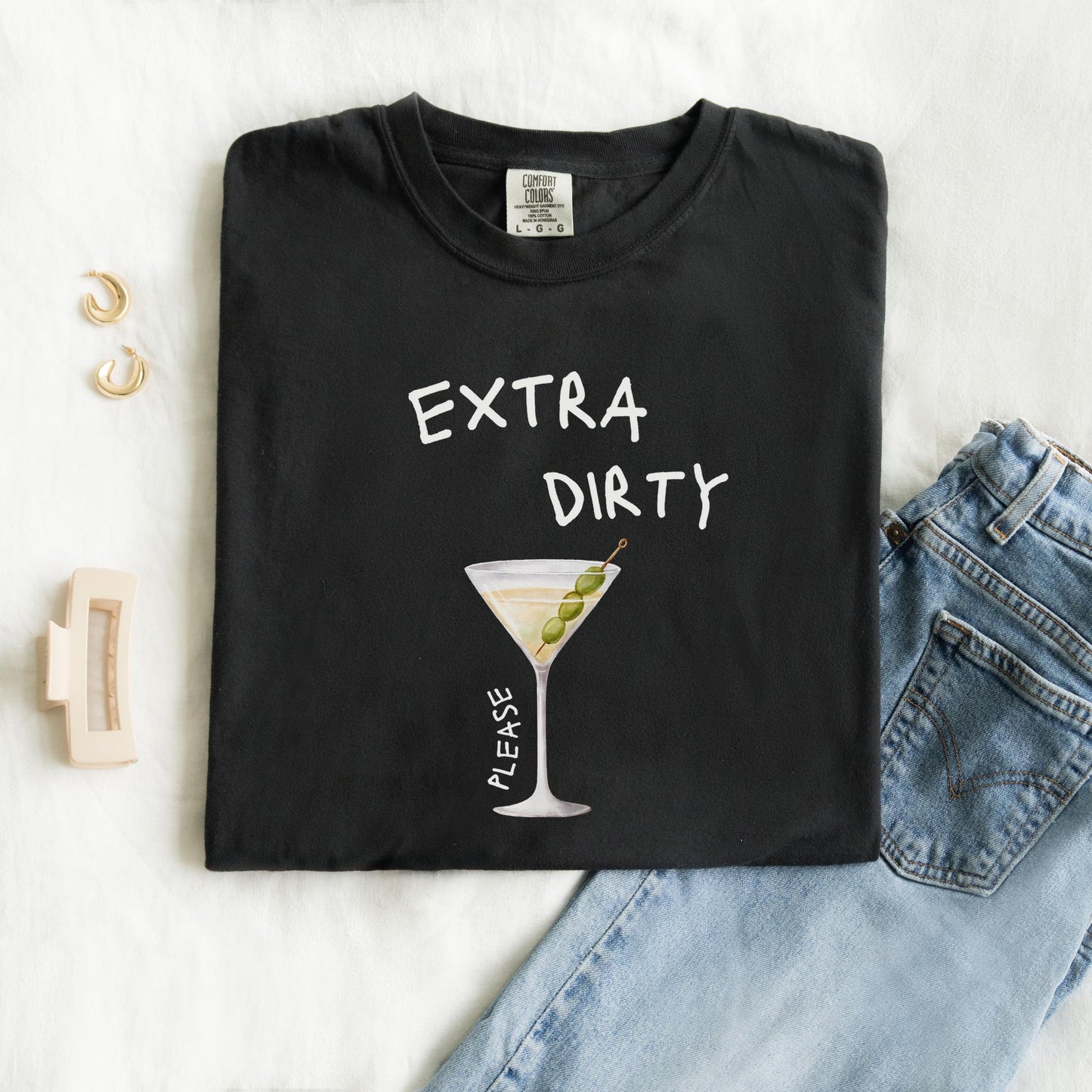 T-shirt design with martini glass filled with clear liquid and three green olives on a pick