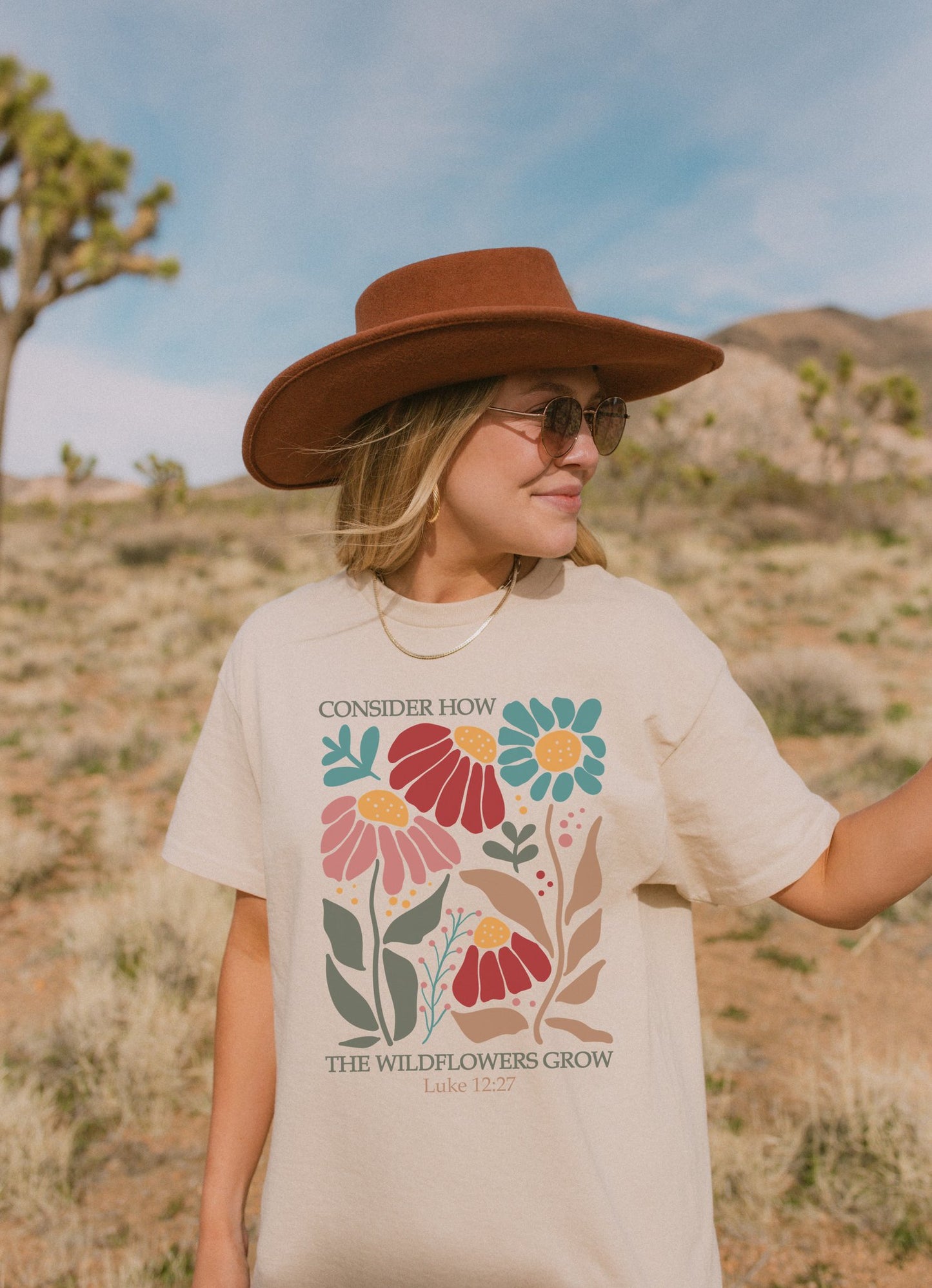 T-shirt with Luke 12:27 Bible verse and colorful wildflowers in red, pink, teal, and brown tones