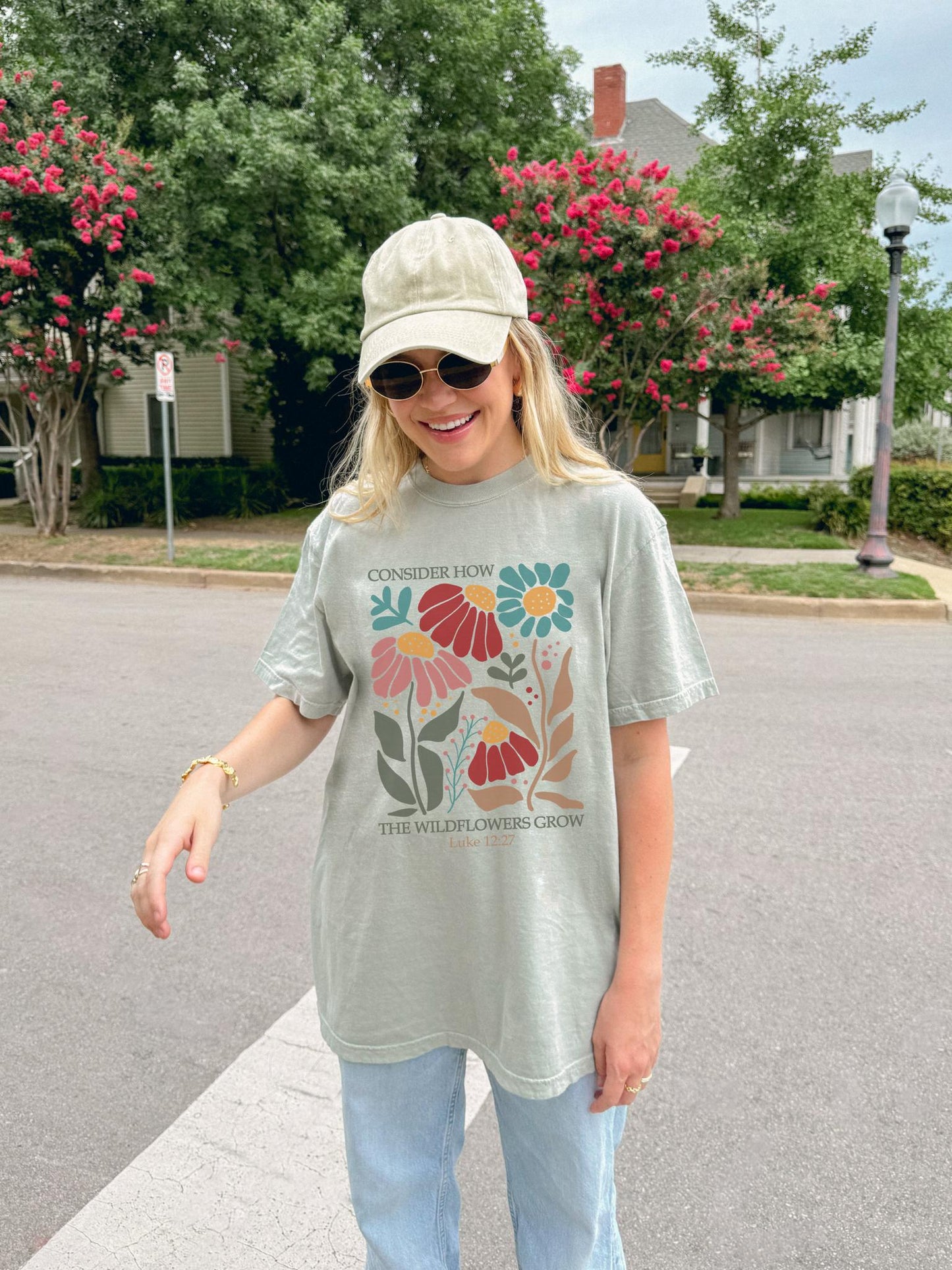 T-shirt with Luke 12:27 Bible verse and colorful wildflowers in red, pink, teal, and brown tones
