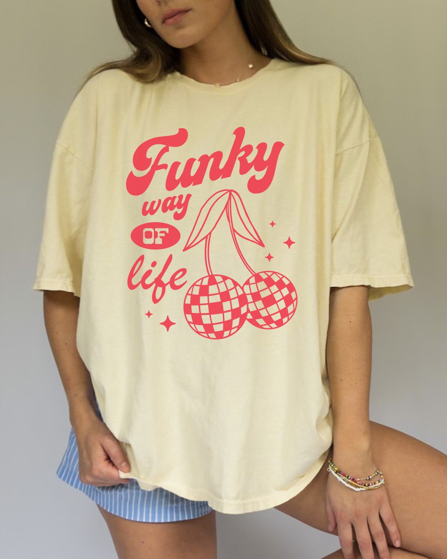 T-shirt with red retro cherry design featuring checkered disco ball cherries and funky typography