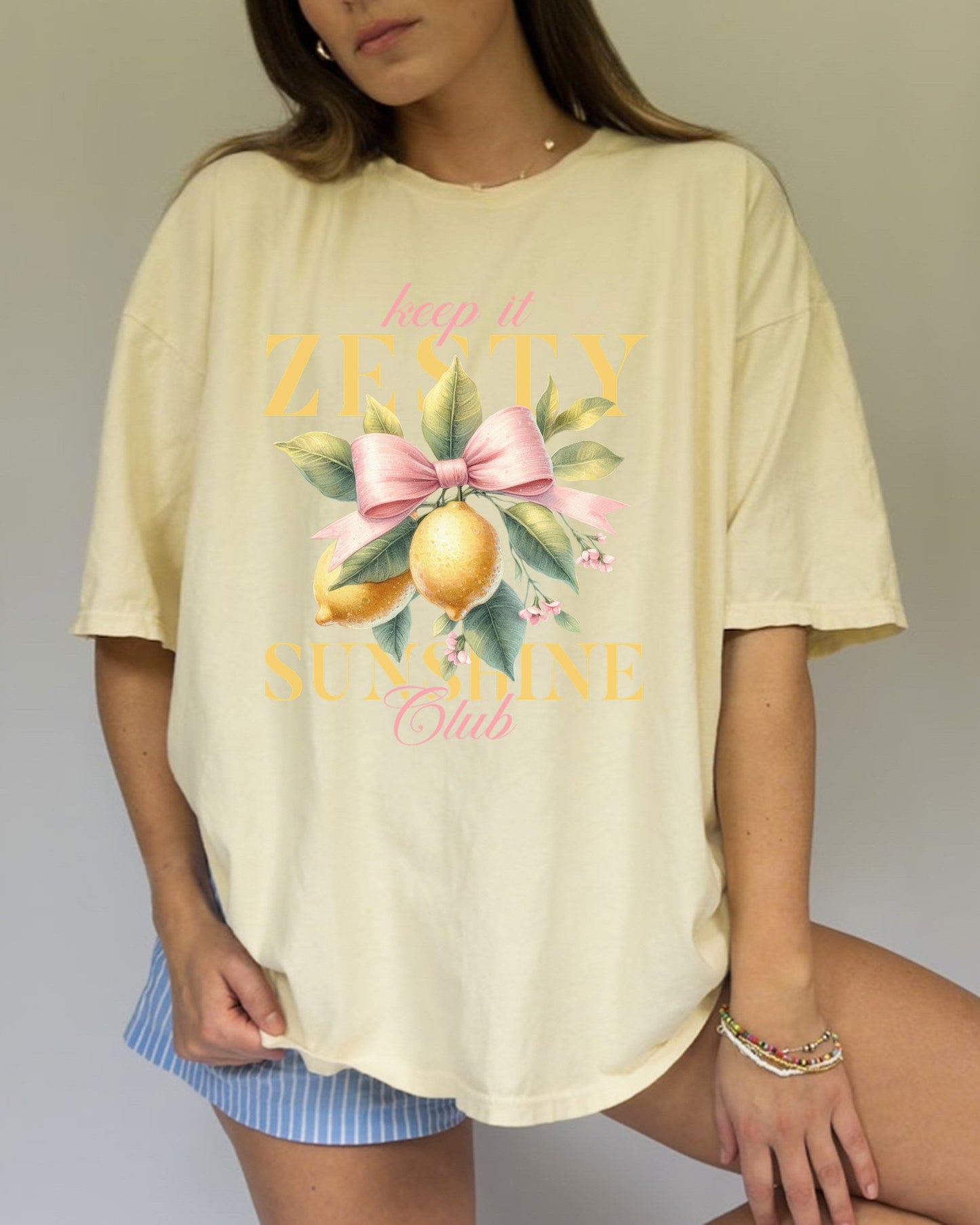 T-shirt with Keep It Zesty Sunshine Club text featuring watercolor lemons with pink bow and green leaves