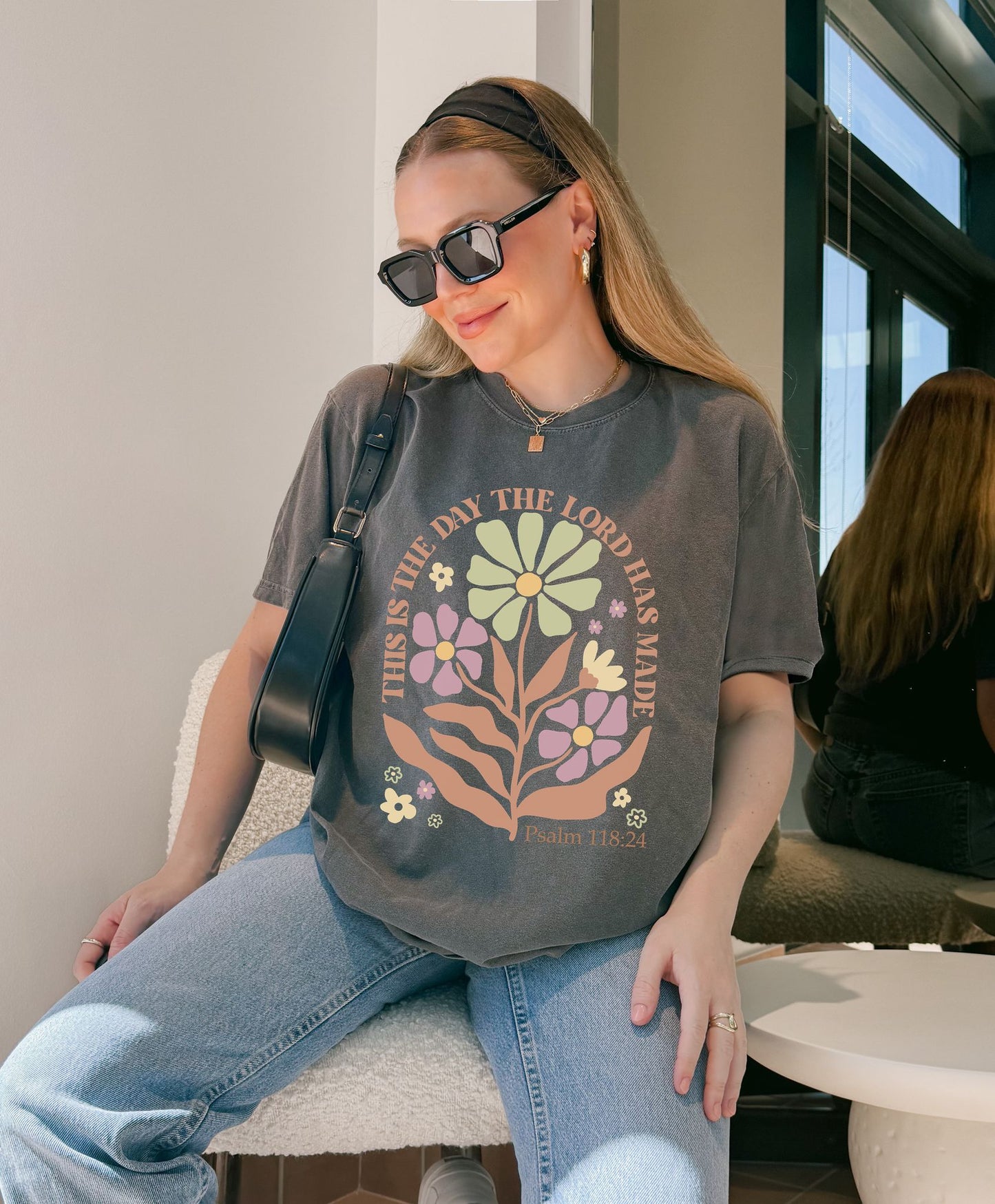 T-shirt with 'This is the Day' text, Psalm 118:24 verse, and floral design with protective hands in sage green, pink, and terracotta colors