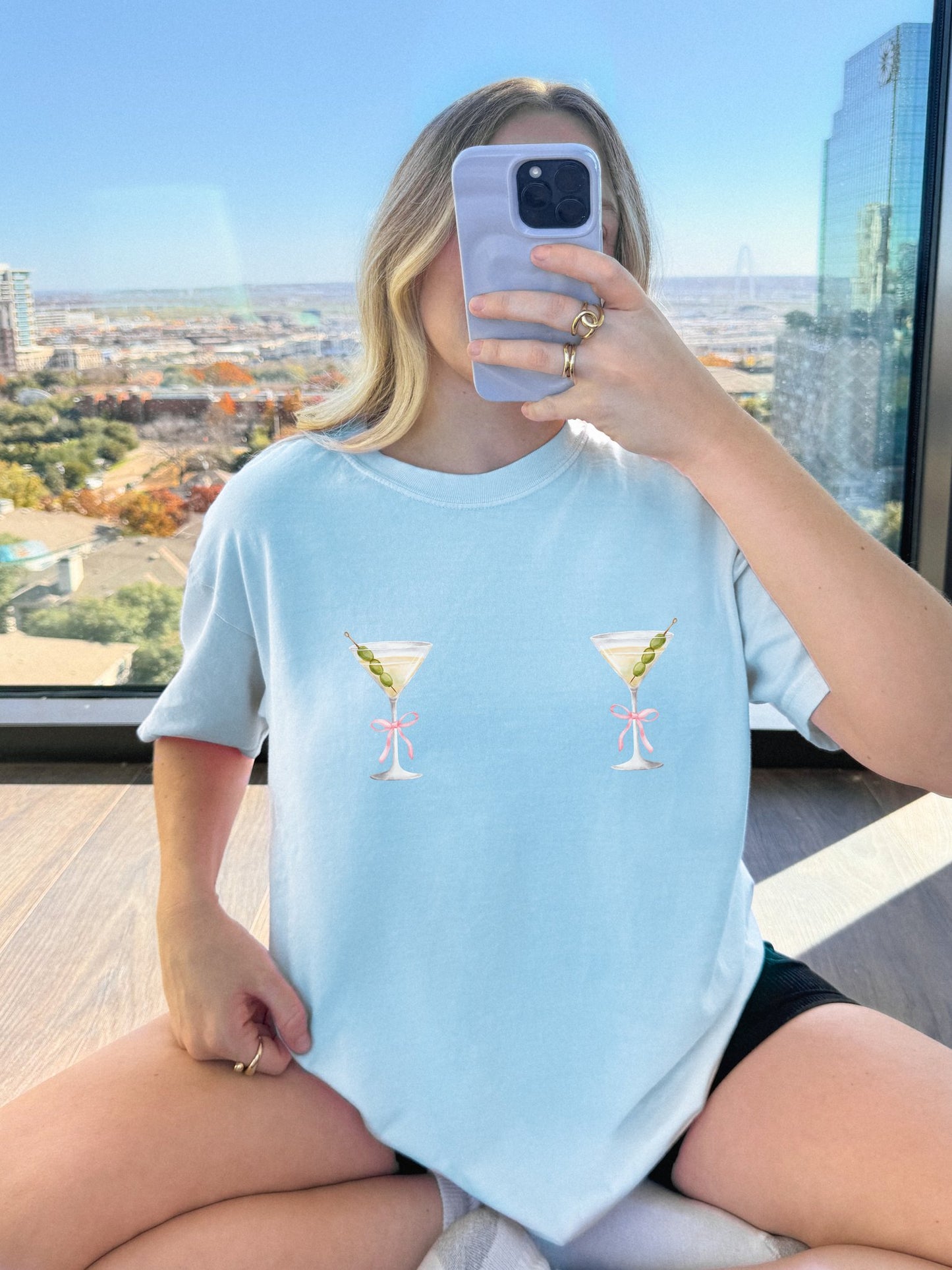 T-shirt design with two martini glasses containing olives and pink bow details creating a humorous cocktail theme