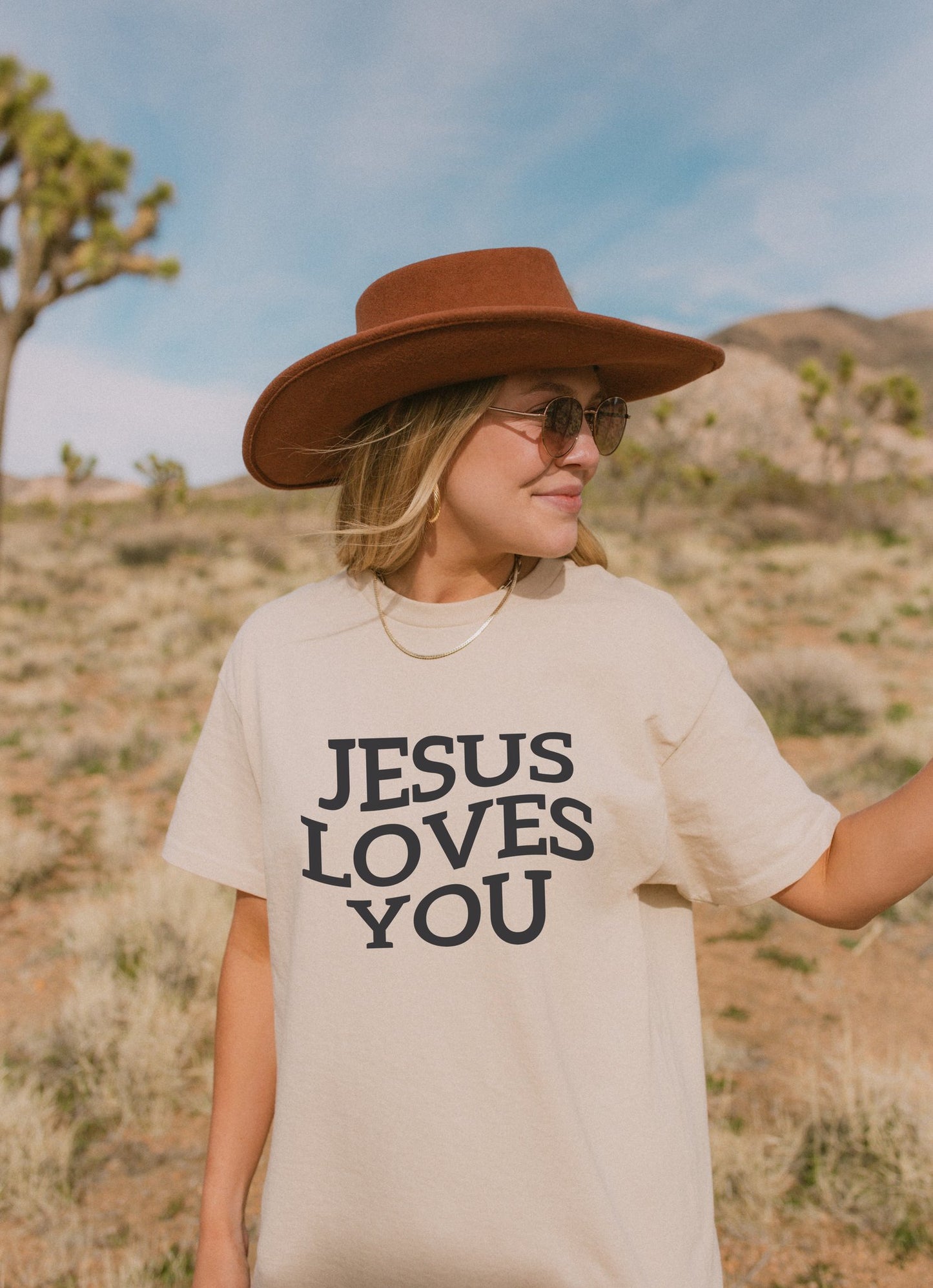 T-shirt with bold black text reading 'JESUS LOVES YOU' in large serif typography