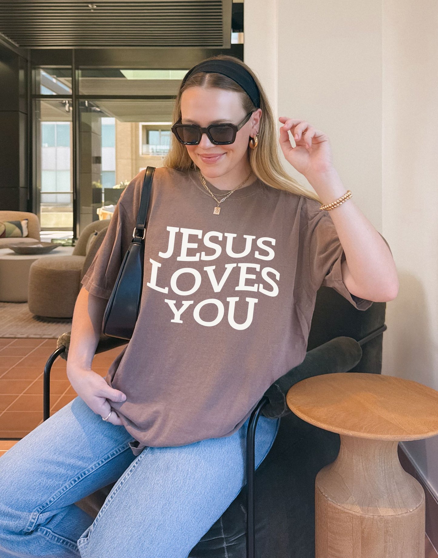 T-shirt with bold black text reading 'JESUS LOVES YOU' in large serif typography