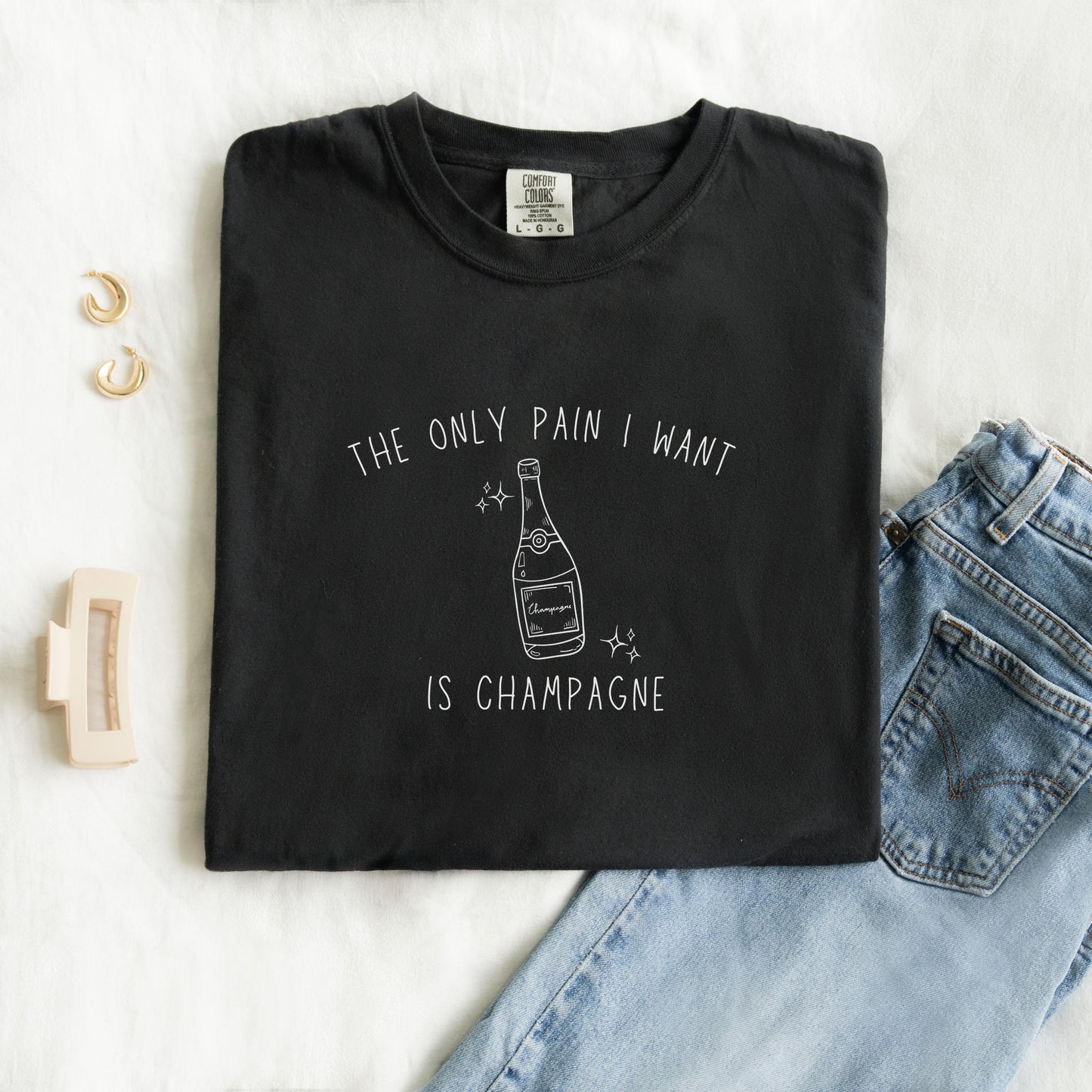 T-shirt with champagne bottle illustration and text 'The Only Pain I Want Is Champagne'