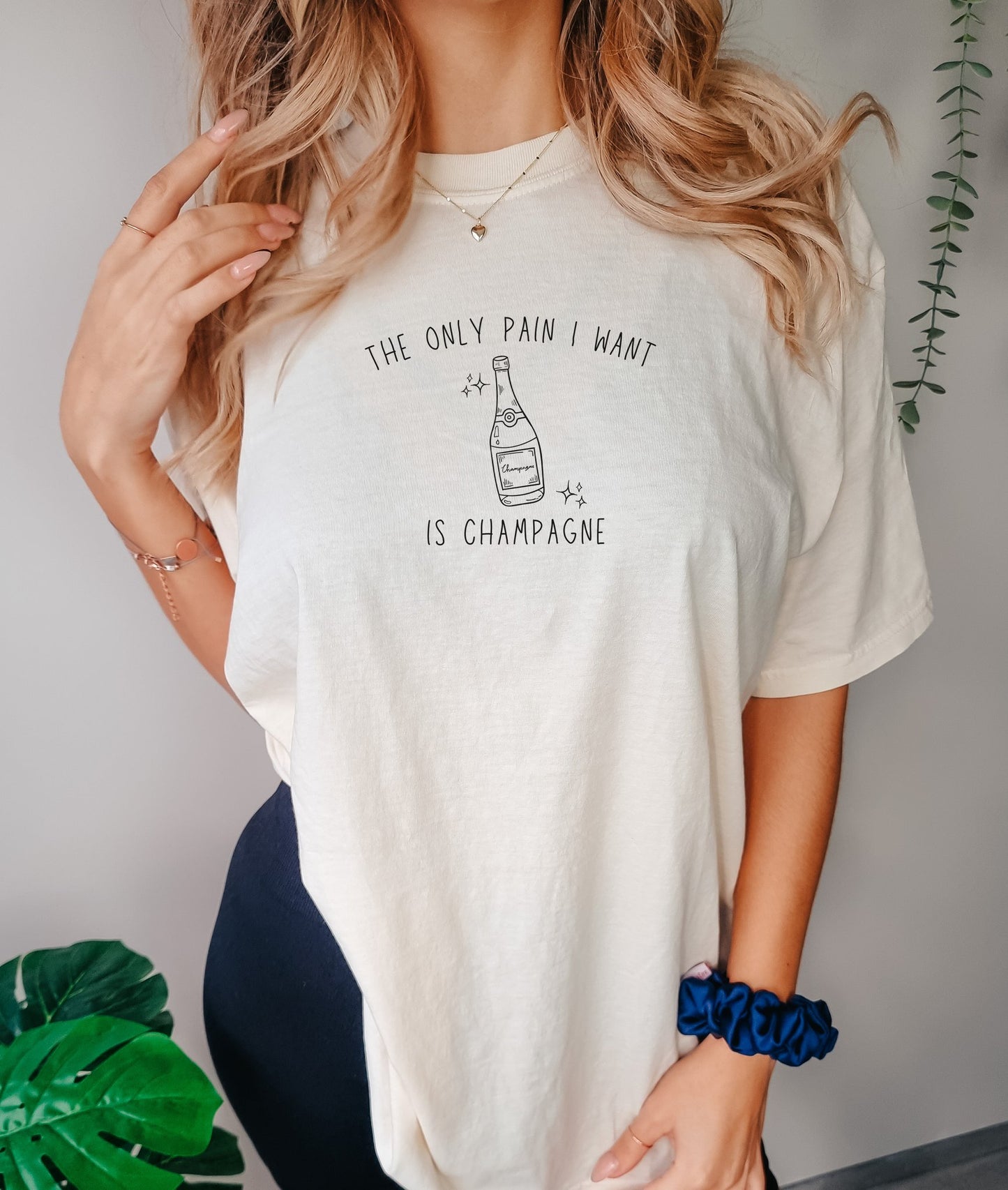 T-shirt with champagne bottle illustration and text 'The Only Pain I Want Is Champagne'