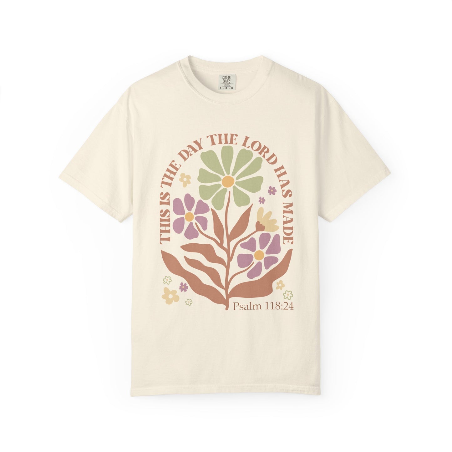 T-shirt with 'This is the Day' text, Psalm 118:24 verse, and floral design with protective hands in sage green, pink, and terracotta colors