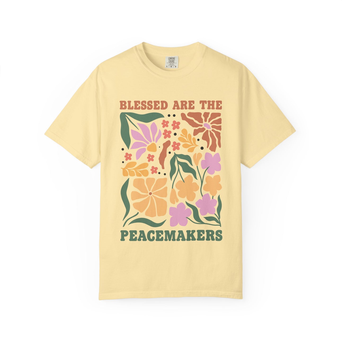 T-shirt with 'Blessed Are The Peacemakers' text surrounded by colorful floral design in pink, coral, yellow and green