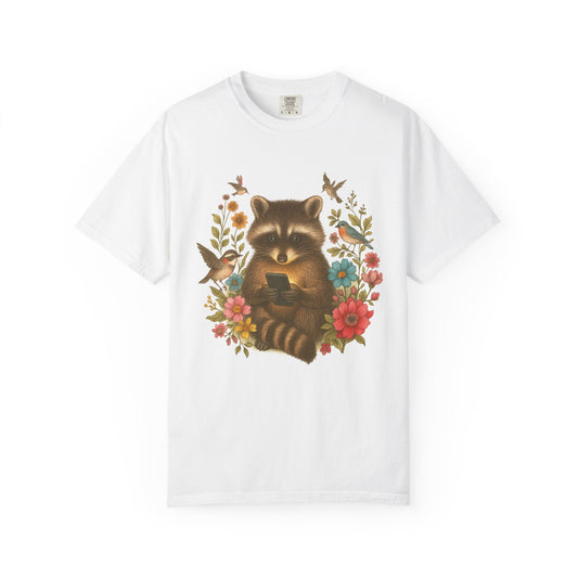 T-shirt design showing raccoon holding phone surrounded by colorful wildflowers and birds