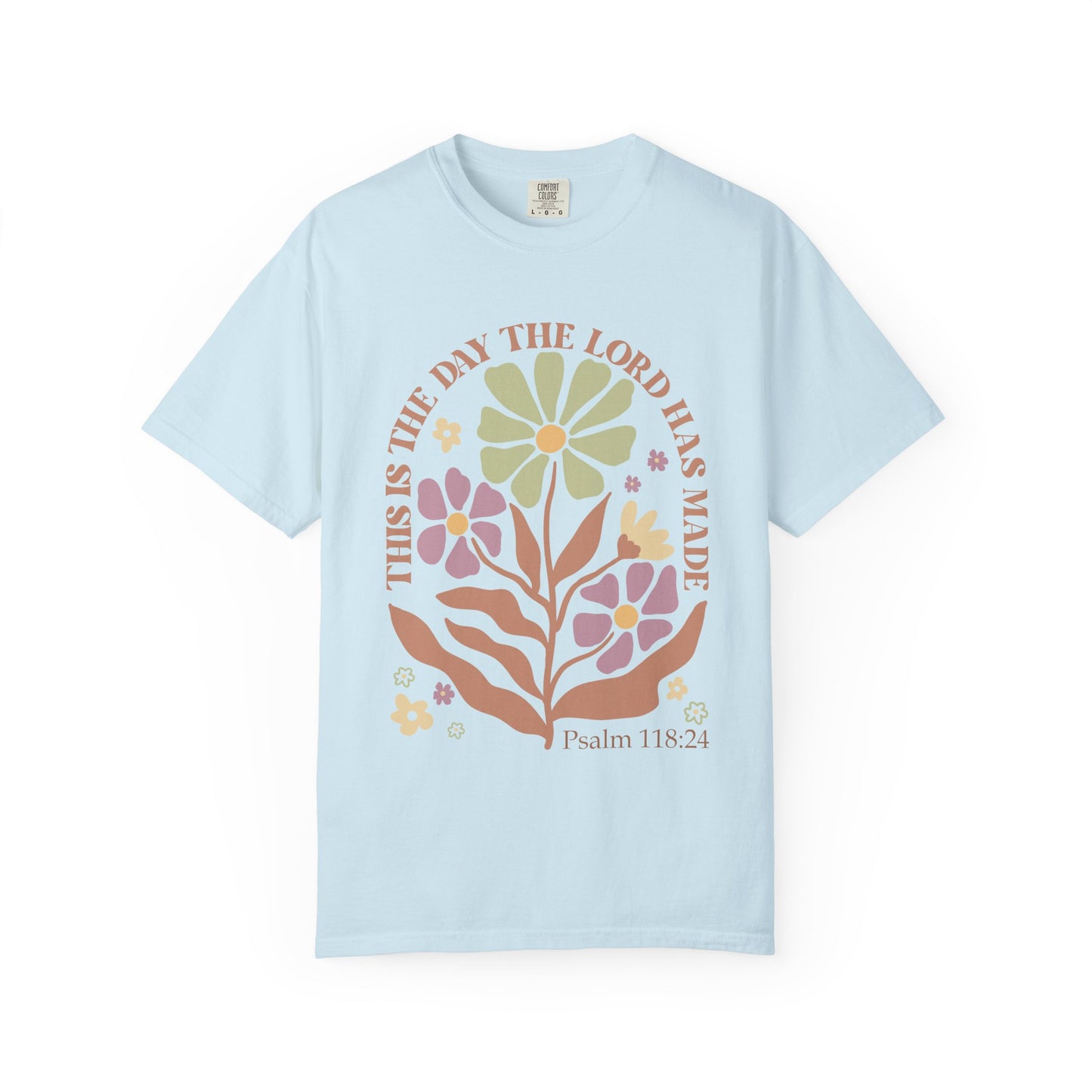 T-shirt with 'This is the Day' text, Psalm 118:24 verse, and floral design with protective hands in sage green, pink, and terracotta colors