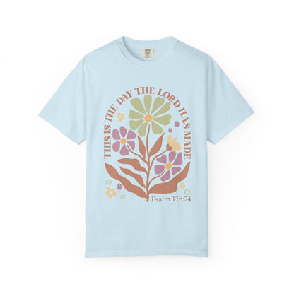 T-shirt with 'This is the Day' text, Psalm 118:24 verse, and floral design with protective hands in sage green, pink, and terracotta colors