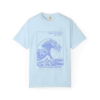 T-shirt with blue ocean wave design featuring 'Ride The Wave Of Faith' and 'Faith Unshaken' text