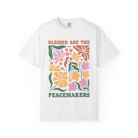 T-shirt with 'Blessed Are The Peacemakers' text surrounded by colorful floral design in pink, coral, yellow and green