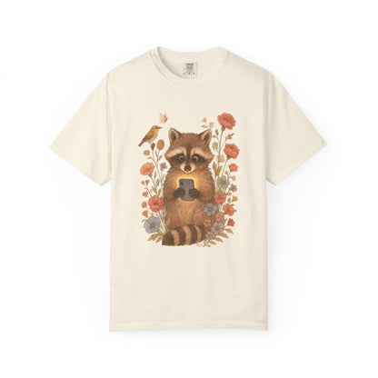T-shirt with cute raccoon holding smartphone surrounded by coral and blue wildflowers
