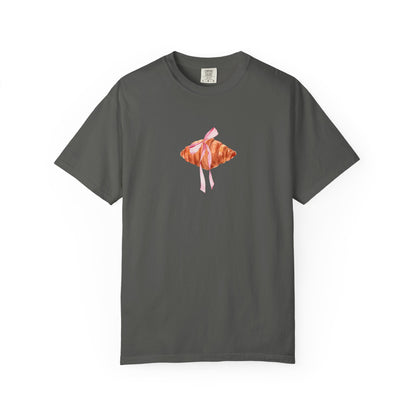 T-shirt with watercolor croissant design featuring golden brown pastry with pink ribbon bow