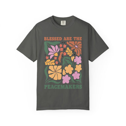 T-shirt with 'Blessed Are The Peacemakers' text surrounded by colorful floral design in pink, coral, yellow and green