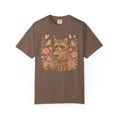 T-shirt with raccoon holding espresso martini glass surrounded by pink roses and birds