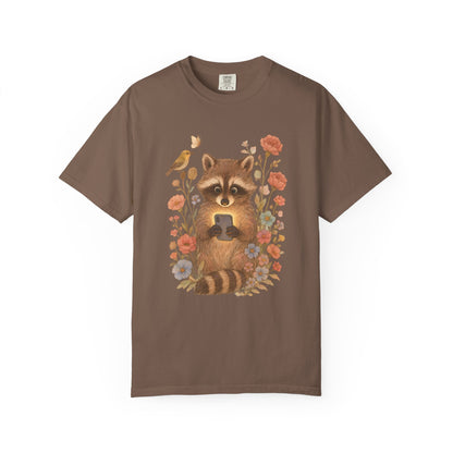T-shirt with cute raccoon holding smartphone surrounded by coral and blue wildflowers