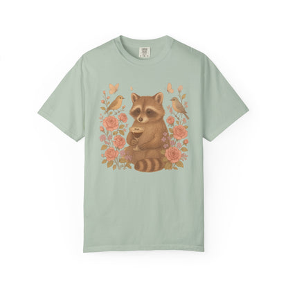 T-shirt with raccoon holding espresso martini glass surrounded by pink roses and birds