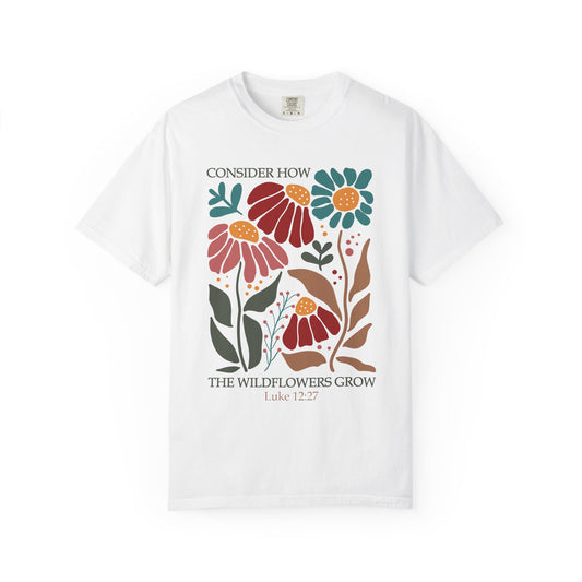 T-shirt with Luke 12:27 Bible verse and colorful wildflowers in red, pink, teal, and brown tones