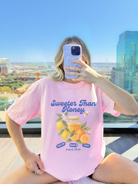 Christian t-shirt with Sweeter Than Honey Psalm 19:10 design featuring watercolor honey jar, citrus fruits, and bees