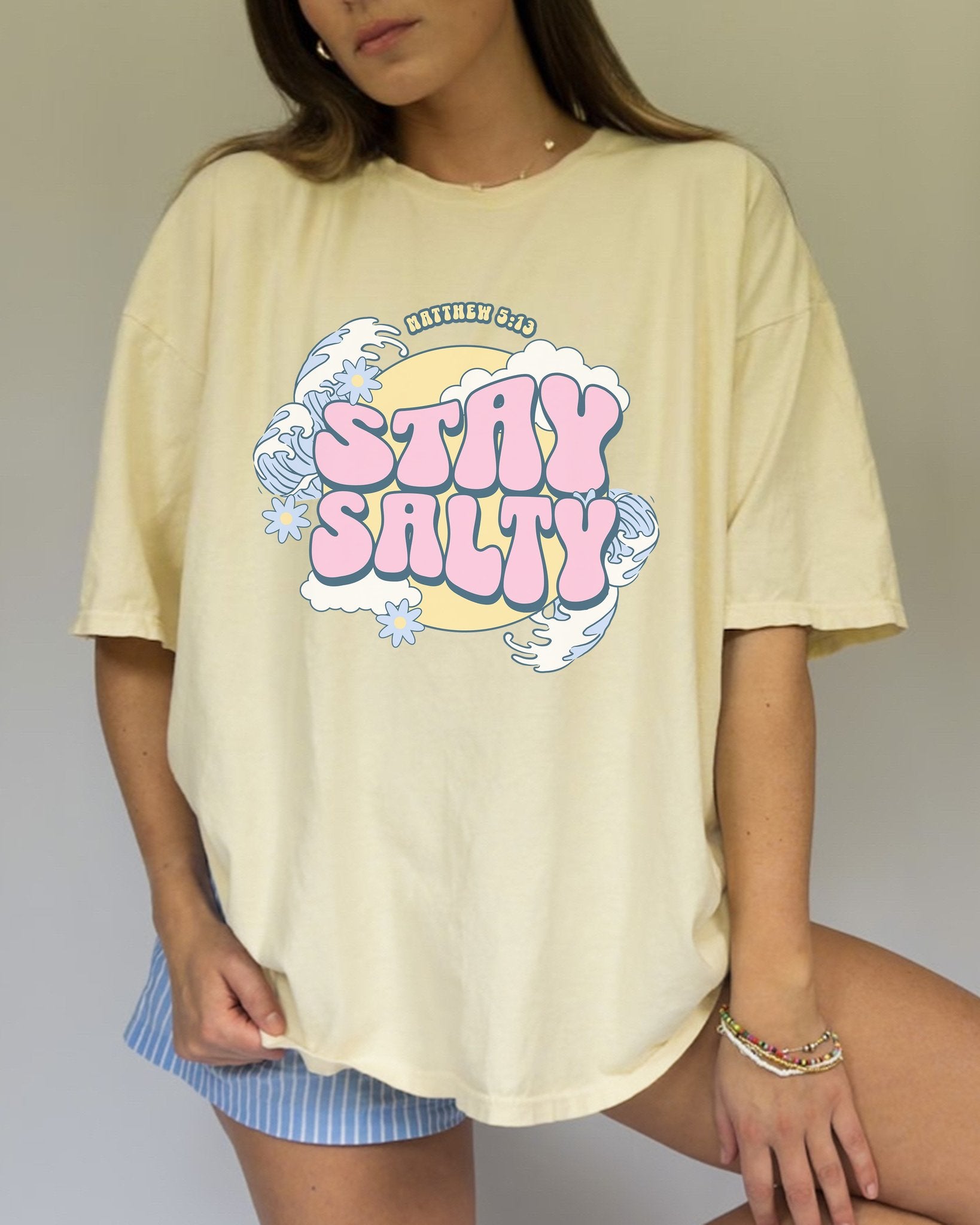 T-shirt with wavy font Stay Salty Matthew 5:13 text in pink bubble letters with ocean waves and flowers