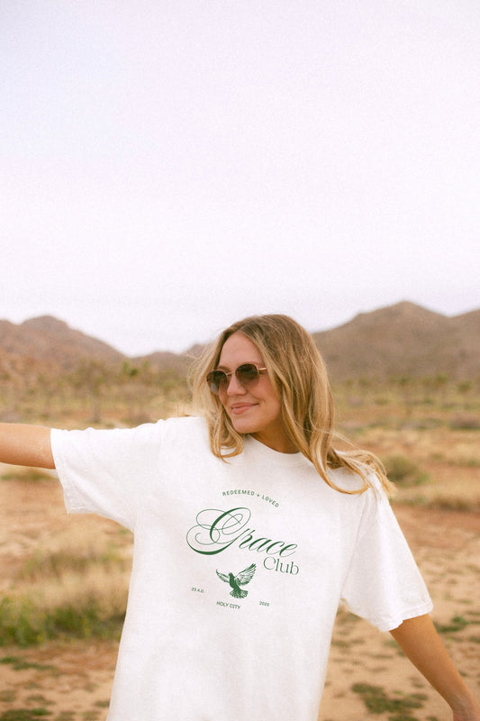 T-shirt with Grace Club text, dove symbol, and Redeemed + Loved message in elegant green design