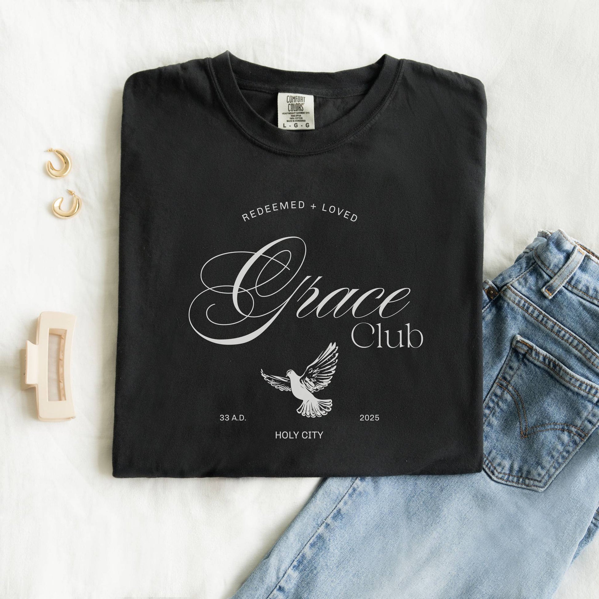 T-shirt with Grace Club text, dove symbol, and Redeemed + Loved message in elegant green design